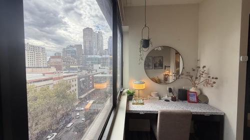 a room with a mirror and a table and a window at Emporium-Melbourne Central-City view in shopping hotspots - Pokemon in Melbourne