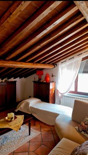 a room with a bed and a couch and a window at La loggia sulle Apuane in Tresana