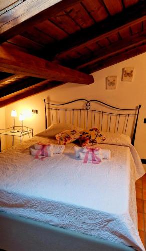 a bedroom with a white bed with a wooden headboard at La loggia sulle Apuane in Tresana