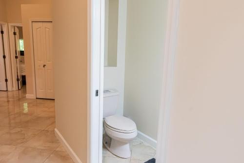 a bathroom with a white toilet in a room at Golden Sands Emerald - Florida's Best - ALL Private Beachfront Estate with TENNIS-PICKLEBALL Court, Pool, Spa in Indialantic