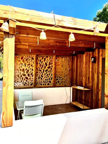 a wooden pergola with two chairs and a table at Le Mas de Scott in Espeluche