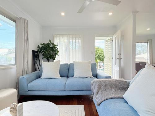 a blue couch in a living room with a window at Family Comfort Modern 3BR Retreat in Brisbane