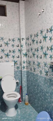 AyodhyaにあるGupta Homestayのバスルーム(トイレ付)が備わります。壁に花が飾られています。