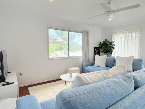 a living room with a blue couch and a tv at Family Comfort Modern 3BR Retreat in Brisbane