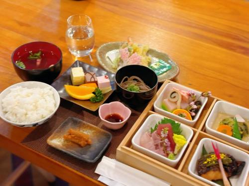 a wooden table with plates of food on it at Hakuba Sun Valley Hotel in Hakuba