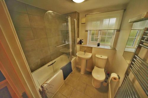 a bathroom with a toilet and a sink and a tub at Broomfield Nook - 2 Bed Ground floor Maisonette close to Harry Potter studio tour in Abbots Langley