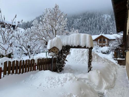 a yard covered in snow next to a fence at Haus Carolus in Elbigenalp