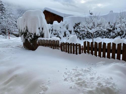 a fence covered in snow in a yard at Haus Carolus in Elbigenalp