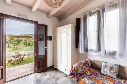 a living room with a couch and a sliding glass door at Agriturismo Alle Riserve Cavagrande in Avola