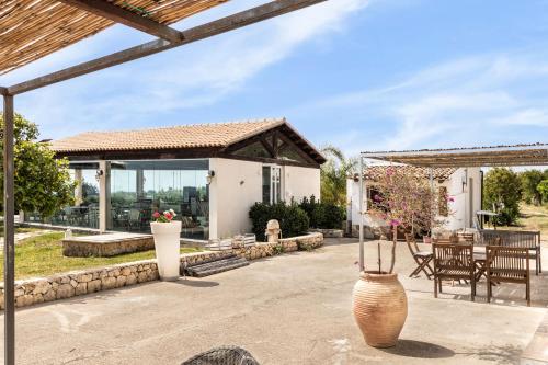a home with a patio with a table and chairs at Agriturismo Alle Riserve Cavagrande in Avola