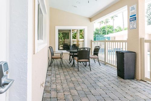 a patio with a table and chairs on a balcony at Golden Sands Emerald - Florida's Best - ALL Private Beachfront Estate with TENNIS-PICKLEBALL Court, Pool, Spa in Indialantic