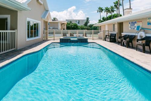 a swimming pool with blue water in a house at Golden Sands Emerald - Florida's Best - ALL Private Beachfront Estate with TENNIS-PICKLEBALL Court, Pool, Spa in Indialantic