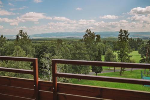 a balcony with a view of a field and trees at ATLAS Hotel Tatry in Vysoké Tatry