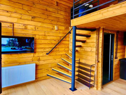 a wooden wall with a staircase and a tv at Sioni Hillside Cottages in Sioni