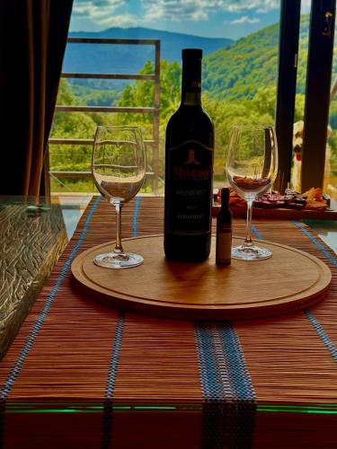 a bottle of wine and two glasses on a table at Sioni Hillside Cottages in Sioni
