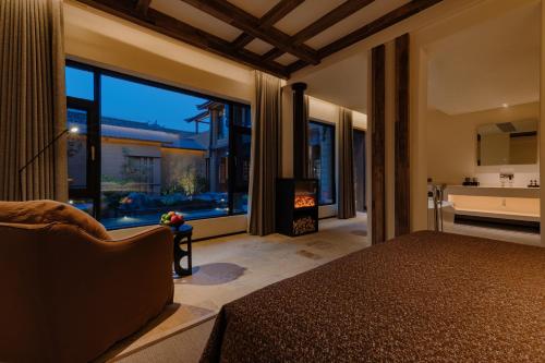 DiannanShaxi Fengyasong Village Hotel的一间带床和大窗户的卧室