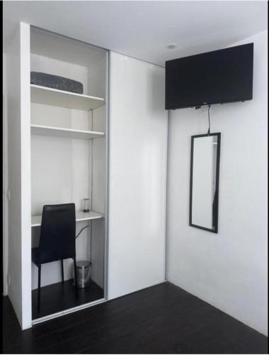 Cette chambre comprend une chaise et un bureau avec un miroir. dans l'établissement Location proche de toute commodités à 1 minute du tramway et à 9 min de centre ville et parking gratuit dans résidence privée, à Nice