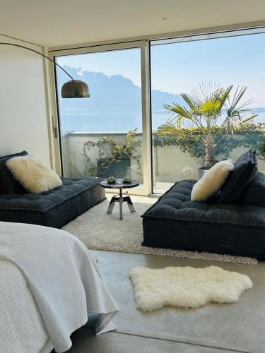 a living room with a couch and a large window at Evasion Lake Front in Montreux in Montreux
