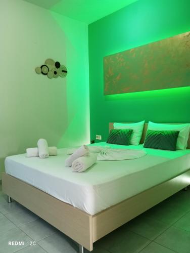 a bedroom with a large bed with green walls at Sunray Apartments in Skala Sotiros