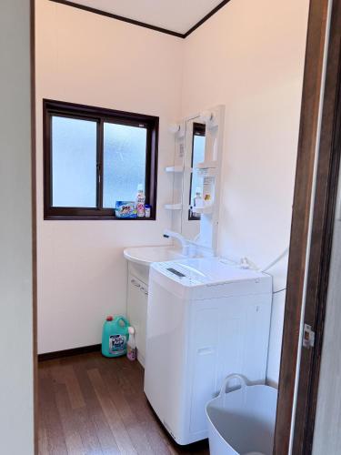 a white bathroom with a sink and a toilet at お宿花水木 in Nagasaki