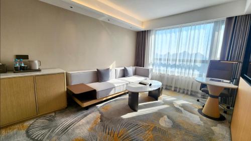 a living room with a white couch and a television at Yanshan Hotel in Beijing