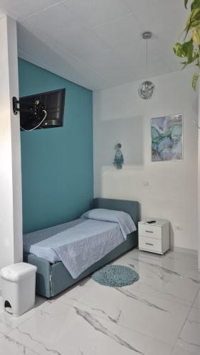 a bedroom with a bed and a blue wall at La piccola Dimora di Sara in Termoli