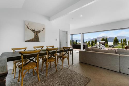 Un comedor con una mesa y sillas y un sofá. en The Lookout - Lake Views, en Wanaka