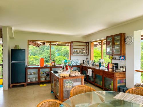 a kitchen with wooden cabinets and a glass table at Sandybridge Eco Farm at Relly's Restaurant in Puerto Princesa City