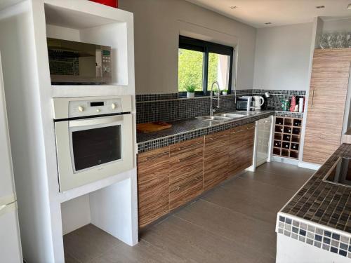 une cuisine avec un évier et une cuisinière dans l'établissement Nouveauté Magnifique Villa, à La Celle-sous-Gouzon