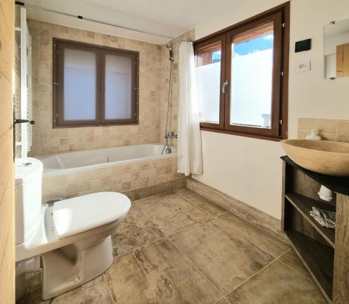une salle de bain avec toilettes, baignoire et lavabo dans l'établissement Private terrace, cosy appartement, ideal couple, bbq,relax, welcome, near La Clusaz, Grand Bornand, Annecy and lake, many sports and entertainment activities summer and winter, à Les Villards-sur-Thônes
