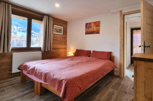 - une chambre avec un lit doté d'un couvre-lit rouge dans l'établissement Private terrace, cosy appartement, ideal couple, bbq,relax, welcome, near La Clusaz, Grand Bornand, Annecy and lake, many sports and entertainment activities summer and winter, à Les Villards-sur-Thônes