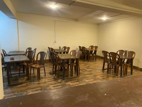 a room filled with wooden tables and chairs at NH1 Hotel and Restaurant in Kargil