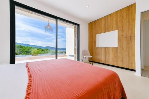 une chambre avec un grand lit et une grande fenêtre dans l'établissement villa vedra, à Pietrosella