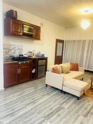 a living room with a couch and a kitchen at Krysta Light Guest House in Kribi