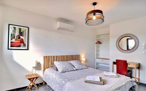 a bedroom with a bed and a mirror on the wall at L Espantée in Saint-Martin-dʼArdèche