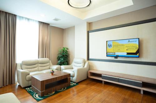 a waiting room with two chairs and a screen at Nagoya Hill Hotel Batam in Nagoya