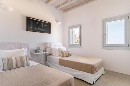 a bedroom with two beds and a chalkboard on the wall at Luxury villa with stunning views above Kalo Livadi in Mýkonos City