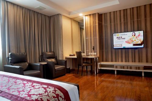 a hotel room with a bed and a tv at Nagoya Hill Hotel Batam in Nagoya