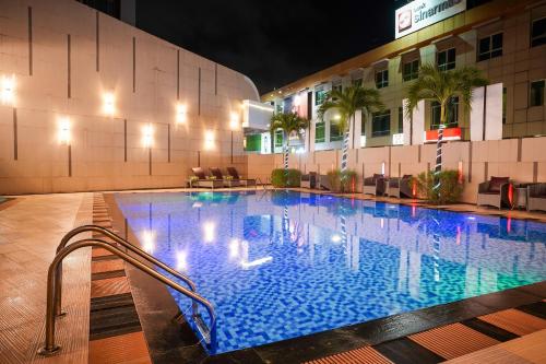 a swimming pool in front of a hotel at night at Nagoya Hill Hotel Batam in Nagoya