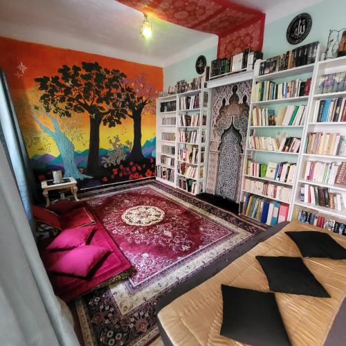 Cette chambre comprend une bibliothèque avec des étagères et une table. dans l'établissement 2p. Jardin calme centre-ville, à Marseille