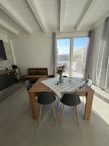 a dining table and chairs in a room with a large window at San Vito Apartment in Palo del Colle