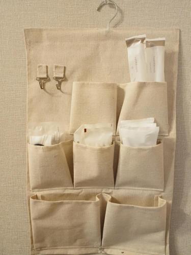 eine Kiste mit Handtüchern und Toilettenartikeln an einer Wand in der Unterkunft UENO 704 jellynehouse in Tokio