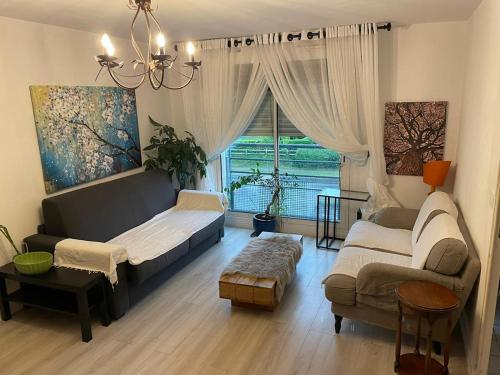 un salon avec un canapé et une fenêtre dans l'établissement Hays and Galia's apartment, à Saint-Grégoire