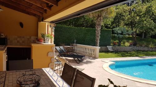 un patio avec une table et des chaises à côté d'une piscine dans l'établissement Villa en drome provençale, belles prestations, à Rochegude
