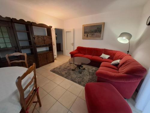 a living room with a red couch and a table at Appartamento 3,5 locali a Figino in Figino