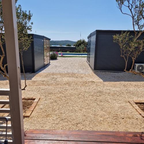 a backyard with a pool and a fence and trees at Mobile Homes Albatross in Pirovac