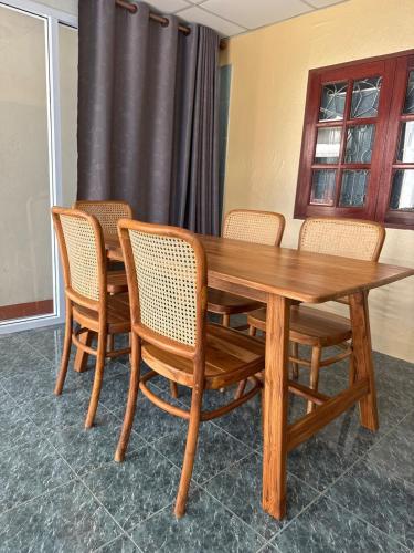 a wooden table and chairs in a room at Traditional Thai House Chaloklum in Chaloklum