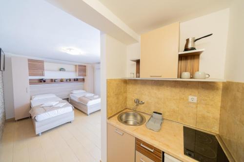 a kitchen with a sink and a living room at Azzuro apartments Budva in Budva