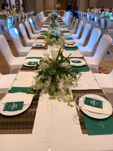 a long table with plates and flowers on it at Shangrao International Hotel in Shangrao