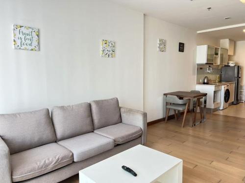 a living room with a couch and a table at 清迈市区Astra condo 屋顶无边泳池可步行至夜市 in Chiang Mai